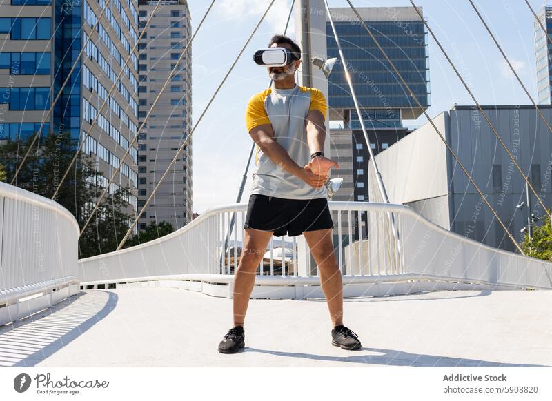 Man using virtual reality headset on urban bridge man city outdoor technology gadget device summer sport fitness indian modern standing active skyline buildings