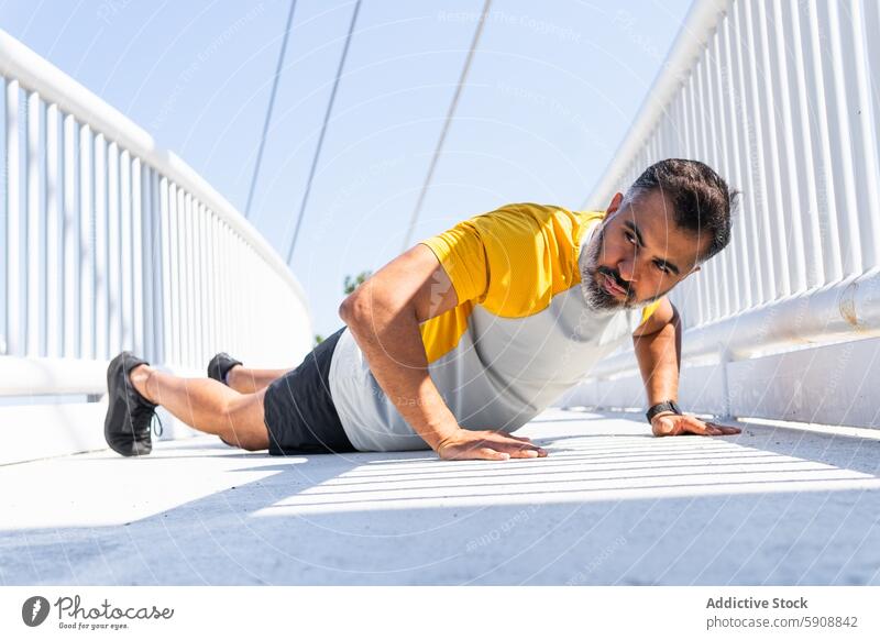 Man performing push-ups on a sunny bridge man exercise summer sport indian fitness outdoor daytime health strength workout male active athletic endurance muscle