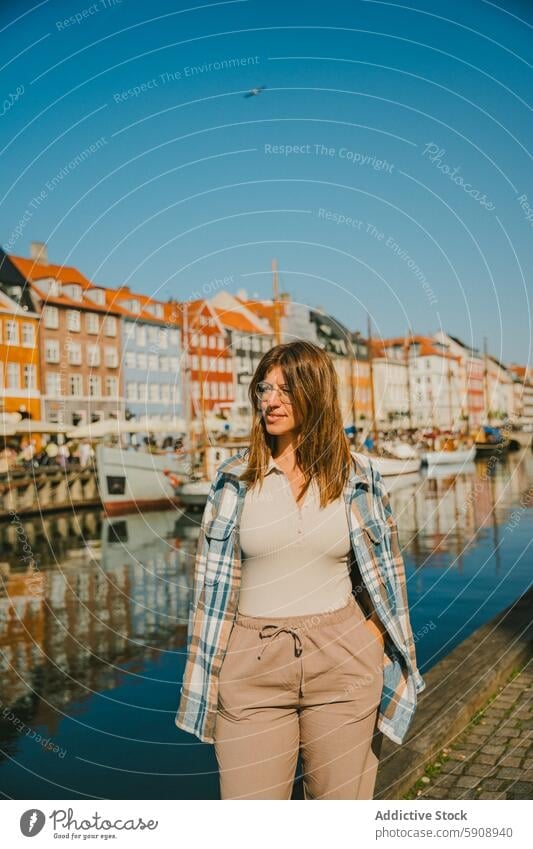 Woman enjoying sunny day by the canal in Copenhagen copenhagen denmark woman travel vacation holiday tourism architecture casual attire historic colorful