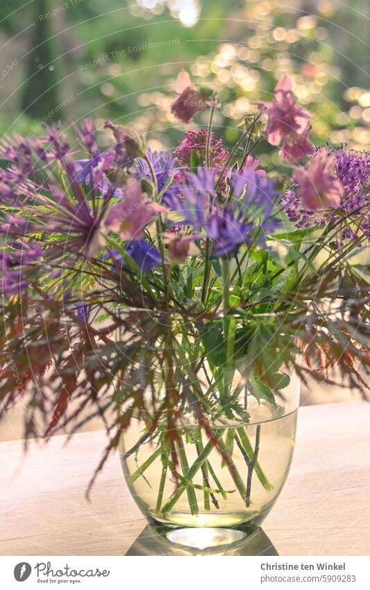 a pretty bouquet of flowers from the garden is on the table outside Bouquet Aquilegia ornamental garlic mountain flake flower slit maple Pink Violet purple