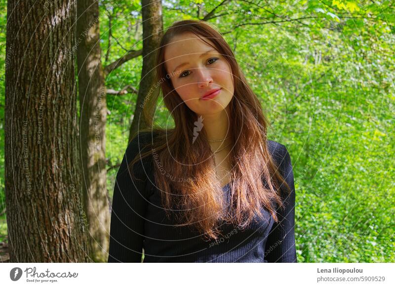 Portrait of a young adult woman in the park 20 years old Full frame backgrounds beautiful brown hair brunette casual central Europe city clothing copy space