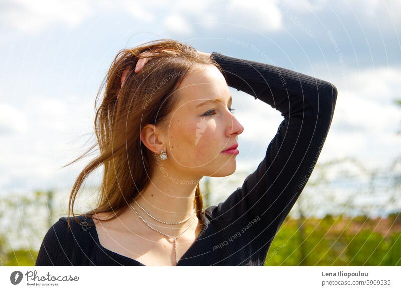 Headshot of a young adult woman against the sky 20 years old Full frame backgrounds beautiful brown hair brunette casual central Europe clothing clouds