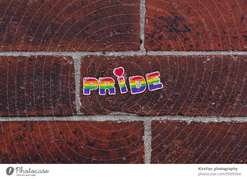 Rainbow Pride Sticker on Red Brick Wall pride lgbtq rainbow sticker brick wall equality inclusion diversity colorful letters urban texture support celebration