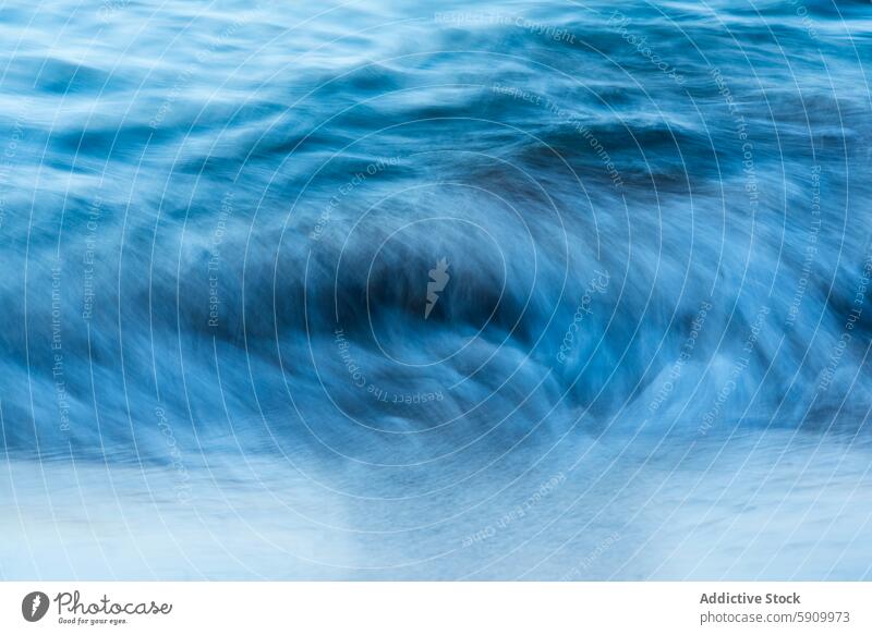 Abstract motion blur of waves on a beach at twilight sea abstract shore water ocean tranquil serene soft focus blue tone nature seascape texture flow tide calm