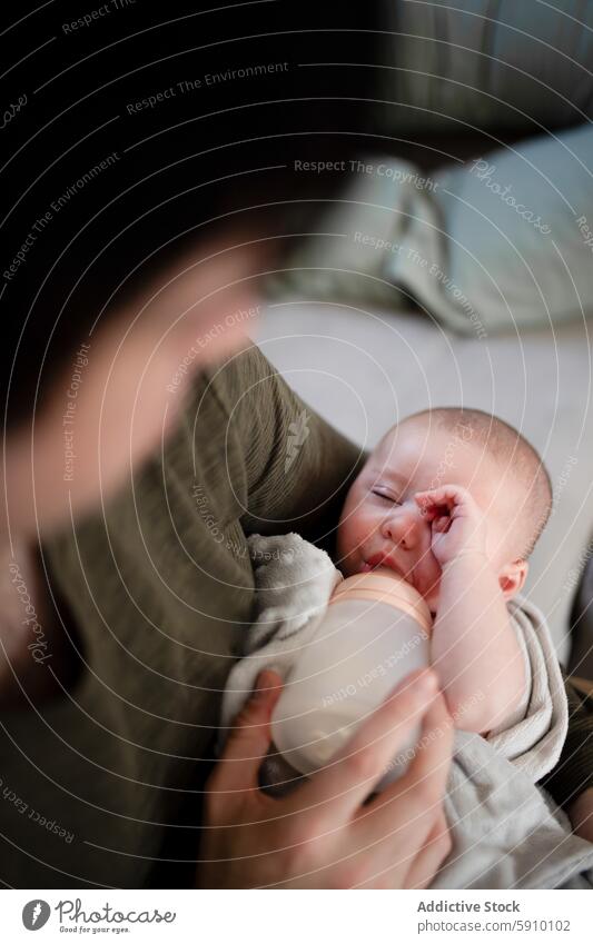 Tender moment of father feeding newborn with bottle baby intimate close-up serene tender eye sleep family bonding care comfort love parent child infant nurture