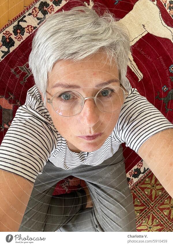 Gray-haired woman stays on the carpet - selfie from a bird's eye view portrait Woman portrait of a woman Senior citizen Carpet Looking into the camera Selfie