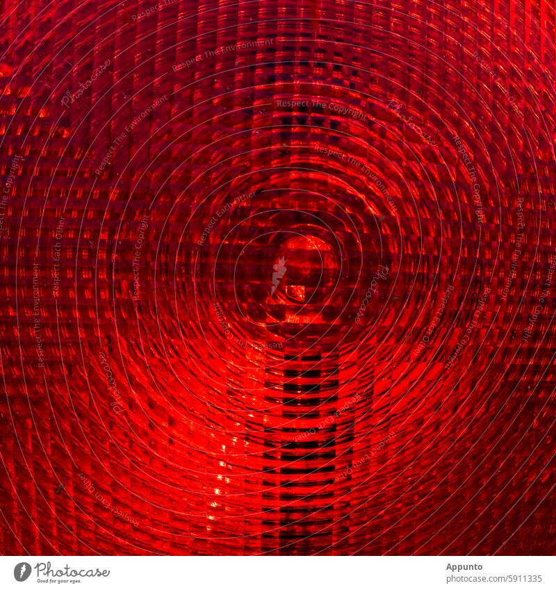 Red alert! - Close-up of the center of a bright red warning light with a transparent surface of circular and honeycomb structures Alarm alarm level Warn