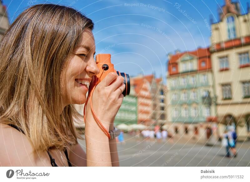 Young Woman Taking Photos in European City woman camera travel tourism photographer European city historic architecture city square colorful buildings memories