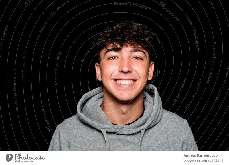 Portrait of a smiling Caucasian man in his 20s wearing a sweatshirt against a dark background. happy male person handsome casual happiness adult caucasian