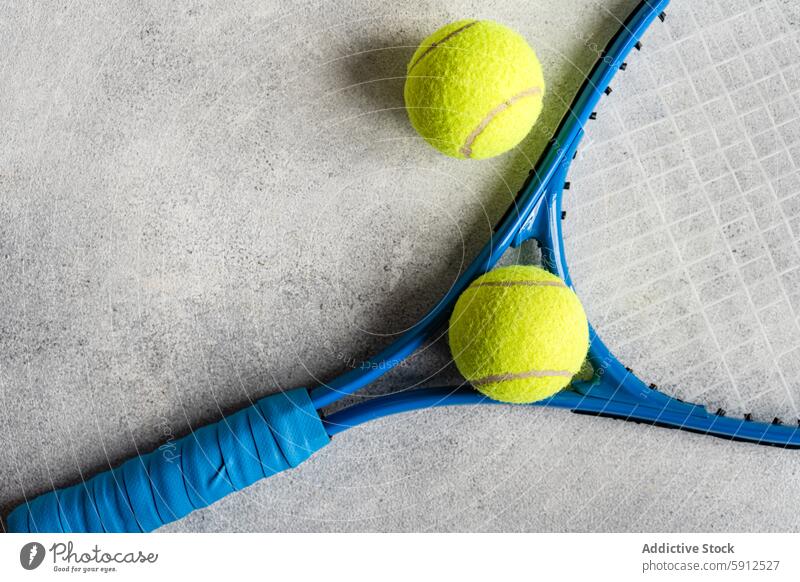 Blue tennis racket and yellow balls on concrete surface blue texture sport gear equipment close-up view bright game play match leisure activity outdoor grip