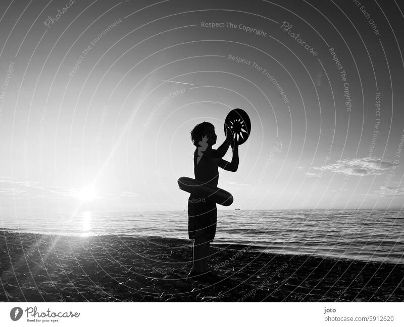 Boy standing with frisbee on the beach against the light person Summer Summer vacation Leisure and hobbies Leisure activity recreational activity