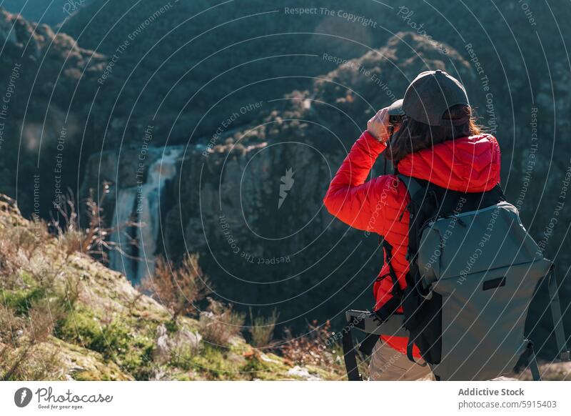 Hiker at Pozo de los Humos observing waterfall in nature woman hiker observation salamanca pozo de los humos binocular adventure travel tourism landscape