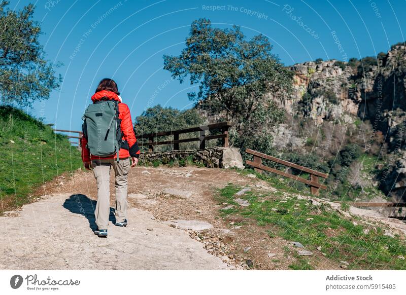 Hiker with red jacket exploring Pozo de los Humos hiker woman backpack trail waterfall nature salamanca pozo de los humos outdoor adventure trekking exploration