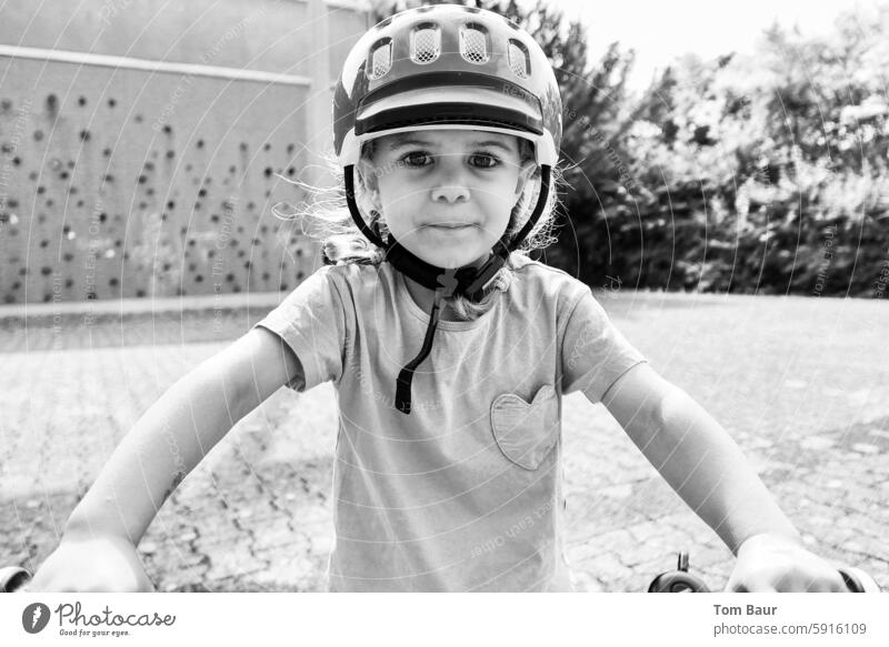 Ready to bike! - Girl with helmet sits on the bike and looks into the camera portrait Helmet Bike helmet Bicycle Infancy Child 3 - 8 years Movement