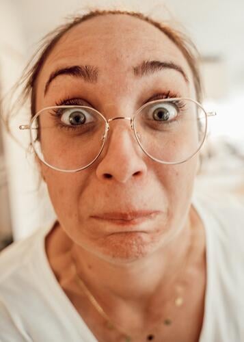 Woman with glasses looks into the camera with wide eyes Eye contact open one's eyes Eyeglasses portrait Feminine Face Human being Adults Looking into the camera