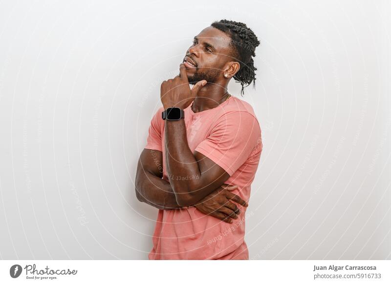 Thoughtful Man in a Pink Shirt Pondering Ideas Against a Simple Background thoughtful man pink shirt contemplation expression concentration thinking