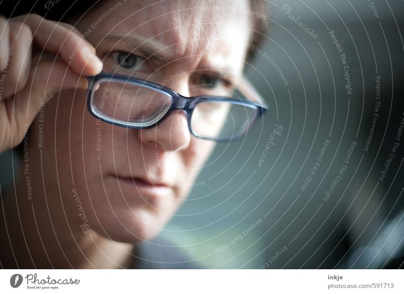 Woman looks seriously over the rim of her glasses Education Adult Education Adults Life Face 1 Human being 30 - 45 years Eyeglasses Reading glasses Observe