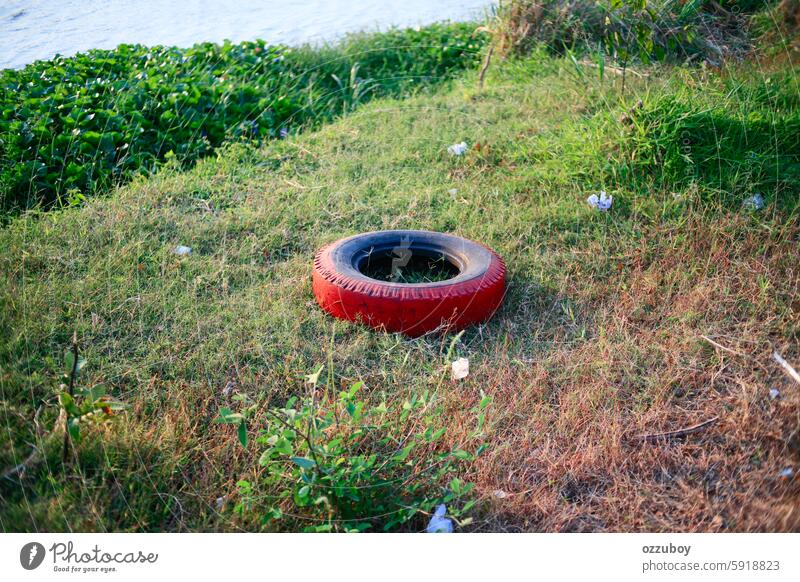 Used car tires with plastic waste on the river bank no people horizontal tire - vehicle part outdoors social issues pollution garbage nature environment old