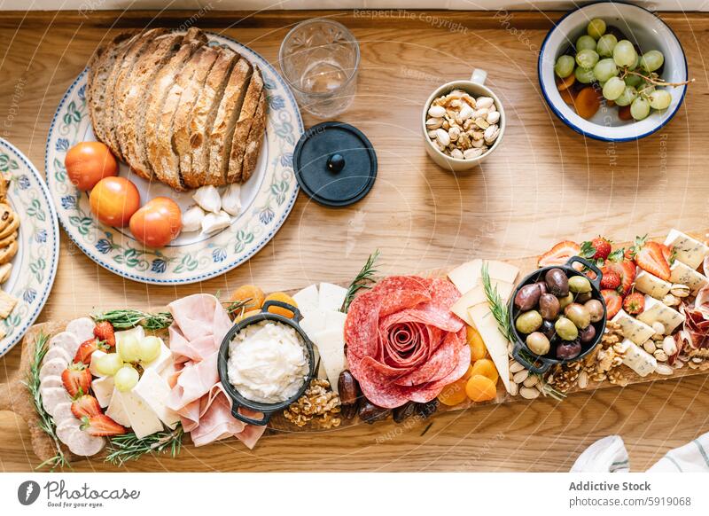 Top view of a gourmet charcuterie board with diverse treats cheese cured meat fruit bread nut table top view artisan luxury dining snack wooden platter spread