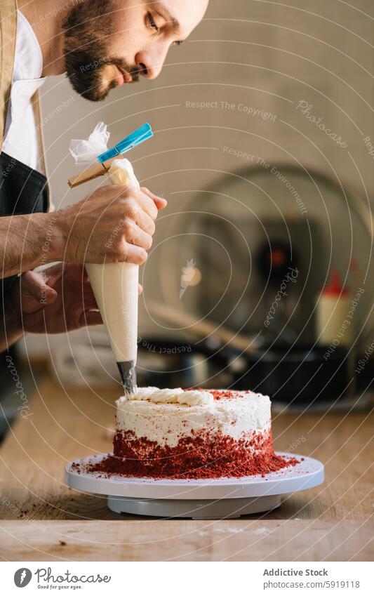 Chef decorating a red velvet cake in the kitchen chef frosting decoration piping bag concentrate cream bake food cook culinary dessert gourmet homemade icing