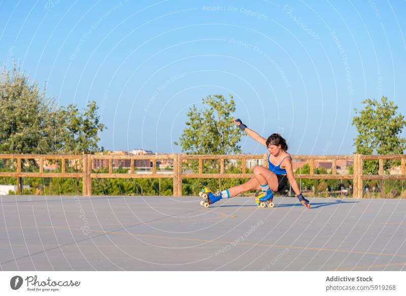 Young woman skating in urban skate park roller skate tricks outdoor athleticism skill young energetic sport clear sky greenery vibrant performance exercise