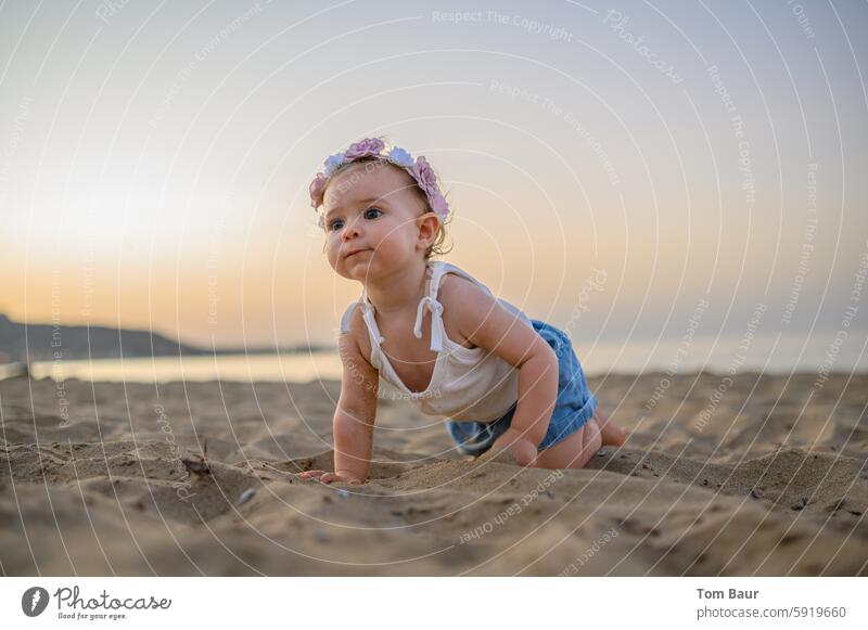 Cute girl crawls on the beach in front of the sunset with flowers on her head Happiness Happy Joy Joie de vivre (Vitality) Exterior shot Child Girl Nature