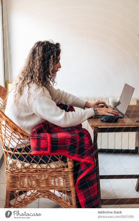 Woman working on laptop at home woman typing freelance project remote using pc netbook browsing job independent self employed online device internet surfing