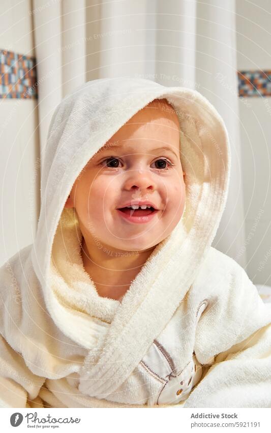 Vertical photo of a baby's face with a hooded dressing gown attention bath bathing bathroom boy caucasian child children clean cleaning cleanliness color