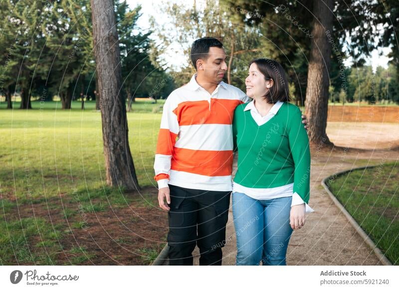 Young Latino couple enjoying a walk in the park latino young together love togetherness connection relationship outdoors nature green casual leisure peaceful