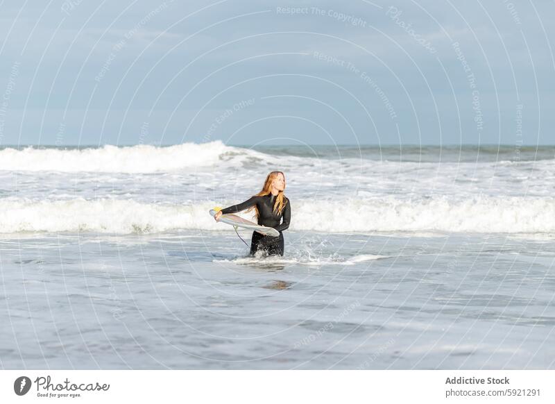 Woman with surfboard in sea woman looking at camera hobby activity pastime sport water shore beach tide wave waterfront seaside nature equipment summer sunshine