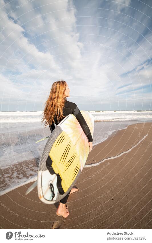 Woman with surfboard walking on wet beach woman coast shore hobby activity pastime sport sea water tide wave waterfront seaside nature seashore equipment summer