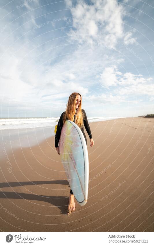 Woman with surfboard standing on wet beach woman coast shore smile hobby activity pastime sport sea water tide wave waterfront seaside nature seashore equipment