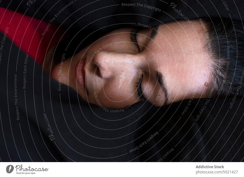 Close-up of a woman sleeping peacefully in dark bedding calm tranquil close-up face eyelash serene relax nap rest pillow comfort quiet home bedroom slumber