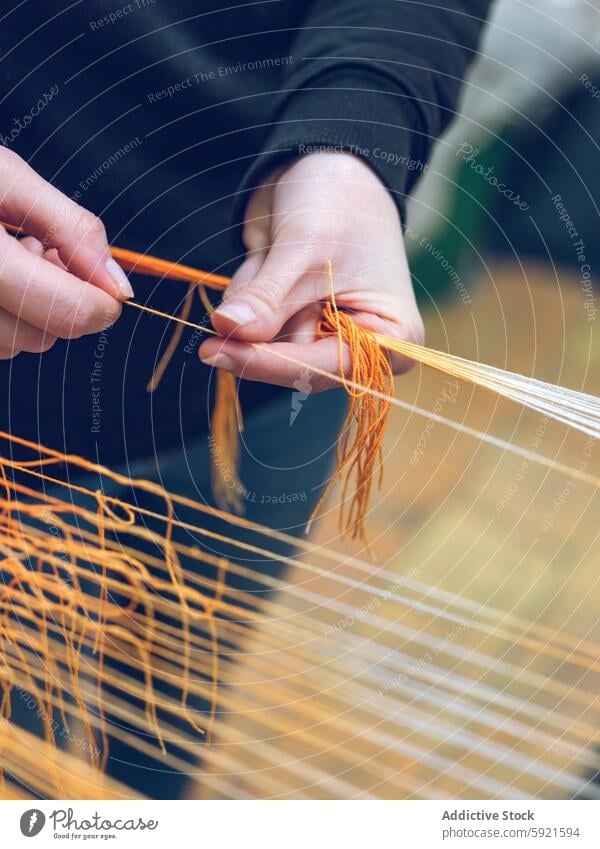 Artisanal Yarn Weaving Technique in Action yarn weaving loom textile craft hand skill technique craftsmanship orange fiber fabric mill production industry