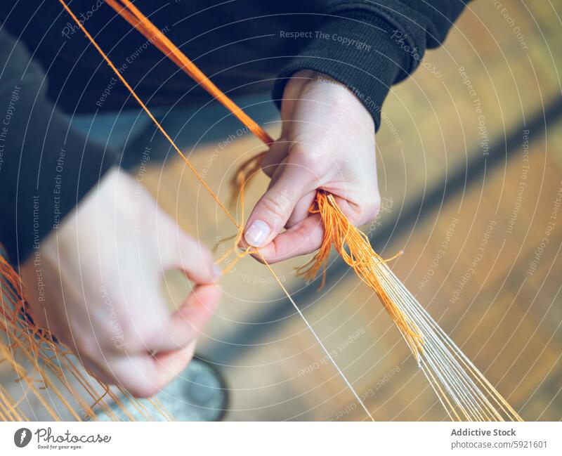 Worker handling threads in a modern textile factory industry yarn worker machinery production close-up skill orange textile production manufacturing industrial