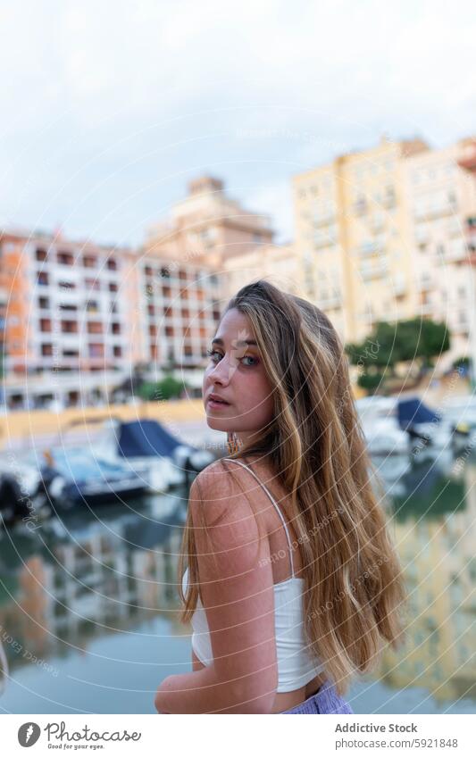 Charming young woman in city in evening tropical embankment sunset charming tranquil summer female calm style street enjoy long hair trendy serene exotic urban