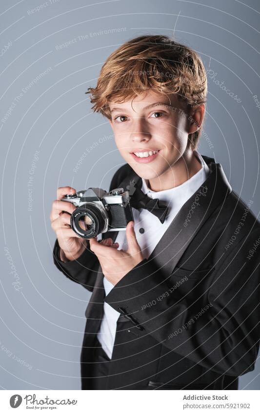 Preteen boy in elegant formal suit with bow tie and photo camera smile professional digital child outfit preteen classy happy cute wear little schoolboy