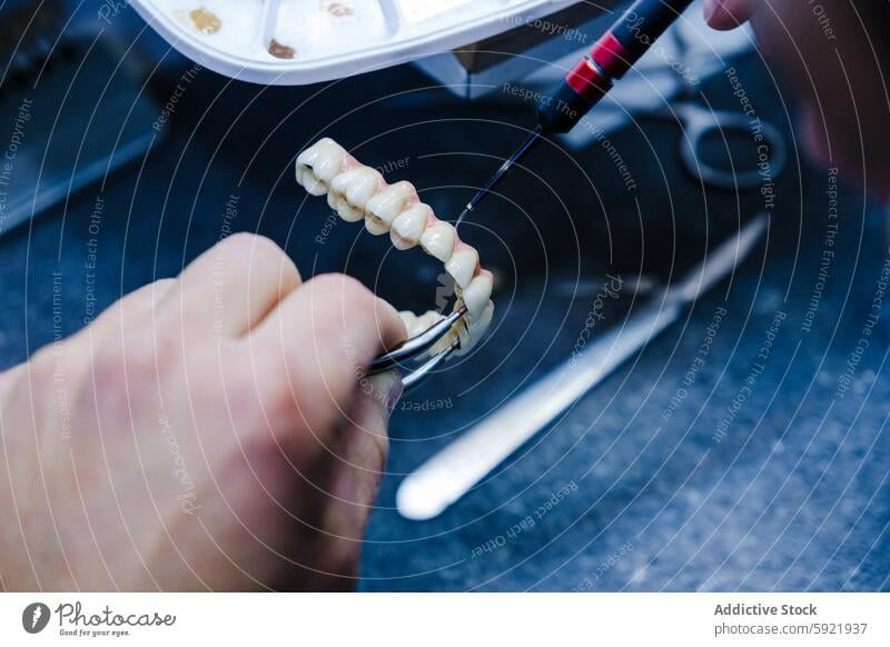 Detailed Dental Prosthesis Work in Progress dental technician prosthesis tool work close-up dental lab craftsmanship artificial teeth workbench dental care