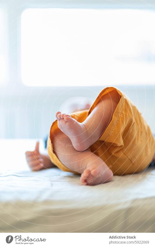 Cute newborn lying on white bed in daytime baby bedroom rest innocent adorable comfort childhood babyhood calm cozy peaceful harmony infant barefoot casual