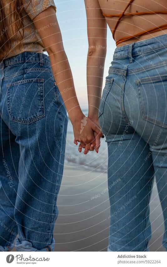 Crop women holding hands on beach girlfriend sea date romantic lesbian love couple together water relationship summer vacation coast shore wet casual affection