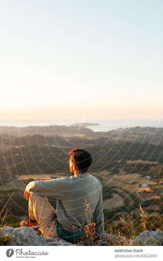 Anonymous tourist contemplating agricultural fields and sea from mount traveler admire mountain plantation nature landscape sky man sunset contemplate tree