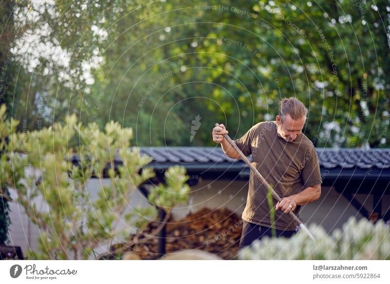 A skilled craftsman engaged in a hands-on outdoor task, carefully raking and maintaining a garden area Craftsman manual labor outdoor work gardening