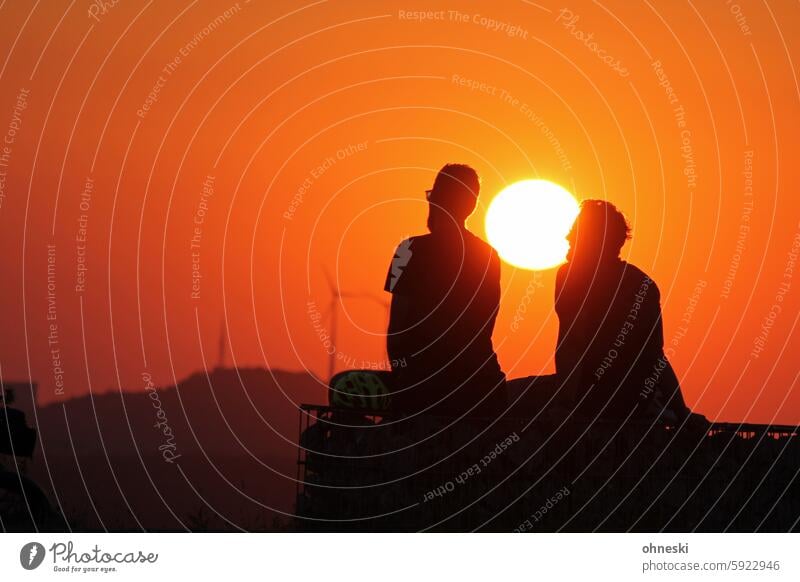 Two people watching the sunset Sunset Dusk Orange Sunlight windmills persons Silhouette Exterior shot Romance Evening Colour photo