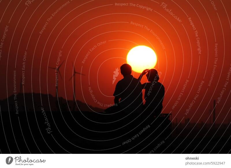 Two people watching the sunset Sunset The Ruhr Slagheap windmills Silhouette Exterior shot Back-light Colour photo Copy Space top Sunlight Evening persons