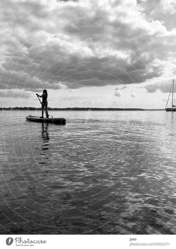 Girl riding a SUP on the Baltic Sea Stand up paddling SEA Aquatics Water sports person Summer Summer vacation Leisure and hobbies Leisure activity