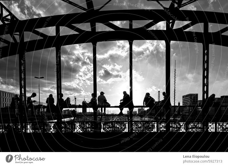 Silhouettes of young people sitting on the steel bridge in the sunset Full frame Hacker Brücke ancient architecture backgrounds black-and-white building