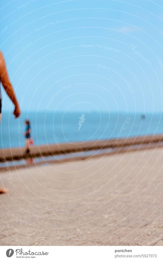 a child in uv-protective clothing stands in the sea. blurred hazy blurriness Anonymous Joy vacation Ocean untroubled Exterior shot Relaxation Vacation & Travel