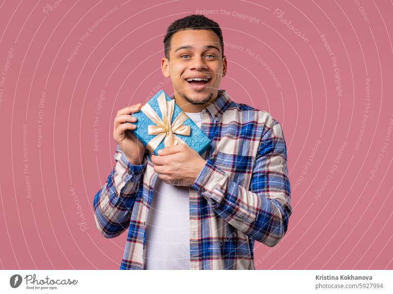 Excited Man Hold Gift Box With Bow. He Is Happy And Flattered By Attention. Guy smiling with present on pink background. Studio portrait. advertisement amazed