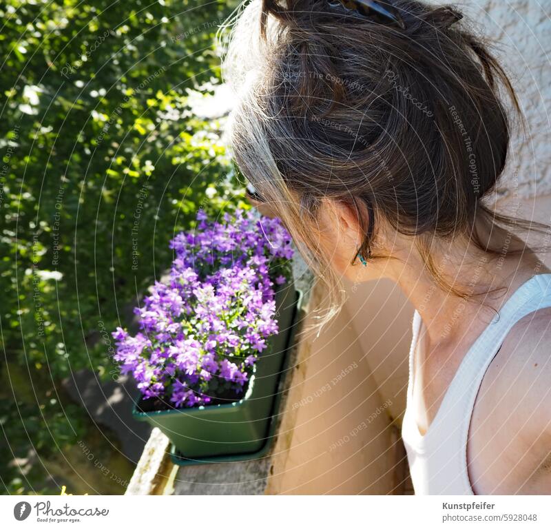 Frau blickt vom Balkon herab in den sonnigen, warmen Morgen. frau sommer sommerlich morgen morgens morgenstimmung aufstehen Tagesbeginn freizeit entstpannt