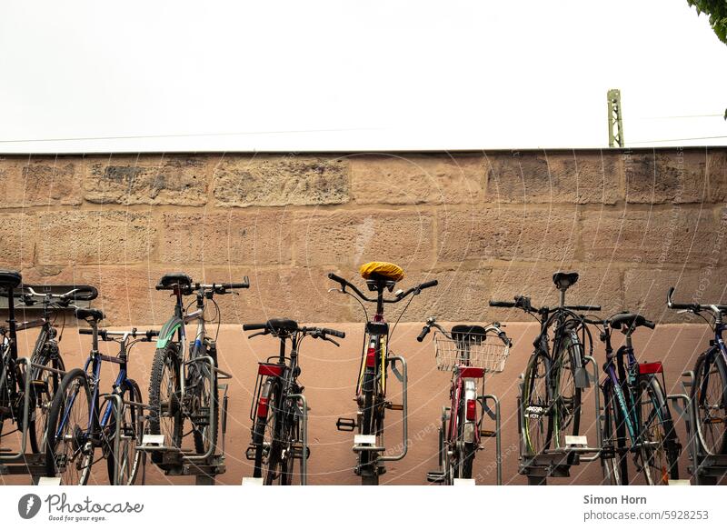 Bicycles in a rack in front of a wall bicycles Bicycle lot Mobility turnaround Parking park and ride Means of transport Eco-friendly Bicycle rack